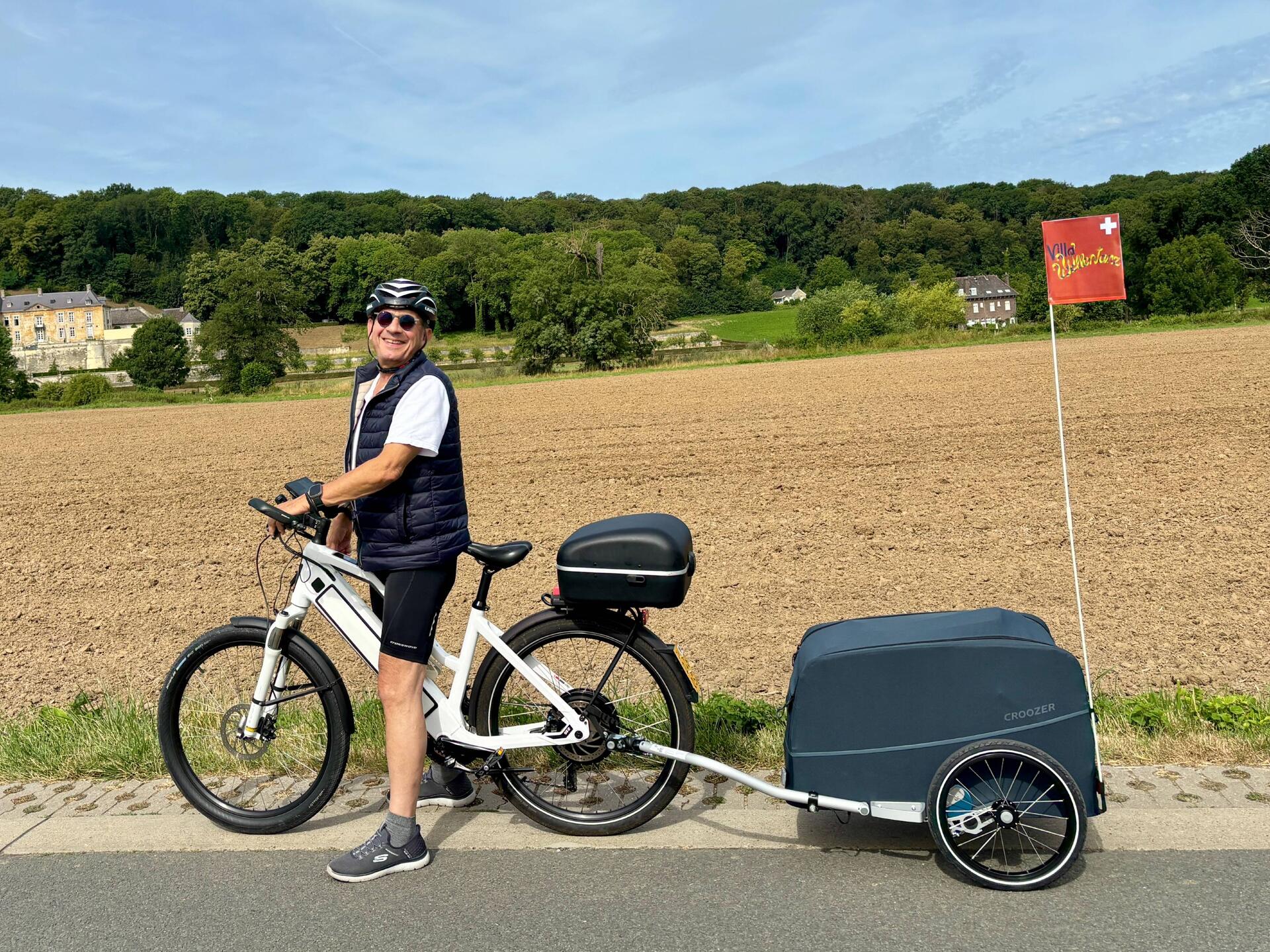 Bereit für die erste Etappe – E-Bike mit Gepäck-Anhänger und Schweizer Flagge